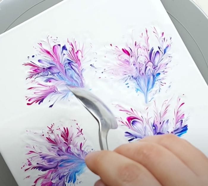 someone is drawing flowers on the side of a computer screen with colored ink and watercolor pencils