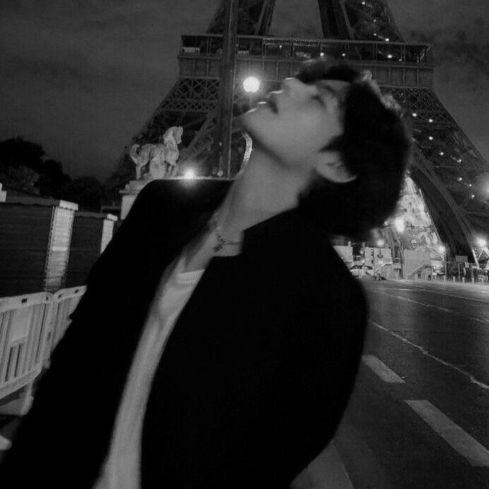 a woman is standing in front of the eiffel tower with her eyes closed