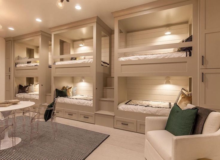 a room filled with bunk beds and white furniture