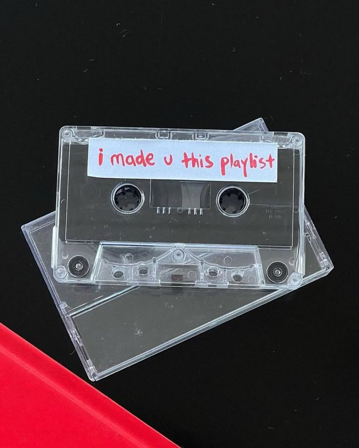 an audio cassette with the words i made this playlist written on it, sitting on top of two plastic discs