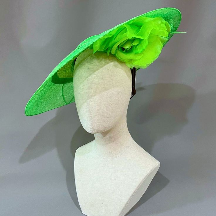 Cool lime green sinamay straw cloth saucer with a peekaboo silk flower underbrim, and accented with graceful curls of sinamay.﻿ Universally flattering, this large saucer style suits most any wearer. Headband, elastic, and comb attachment for easy, comfortable wear. Lifted Millinery headwear is constructed with time honored techniques and fine craftsmanship. All hats are meticulously blocked and sewn by hand without the use of adhesives to attach trims. This ensures a long lasting hat with the ability to be retrimmed throughout the years. A hat box for careful storage is included with every hat purchase. Please allow one week, from date of purchase, for your hat to be shipped. Green Fascinator With Handmade Flowers For Party, Spring Sinamay Mini Hats For Races, Kentucky Derby Green Fascinator With Handmade Flowers, Spring Adjustable Sinamay Fascinator, Summer Sinamay Fascinator For Races, Green Fitted Fascinator For Kentucky Derby, Green Fitted Fascinator For Races, Green Fitted Fascinator For Church, Fitted Green Fascinator For Races