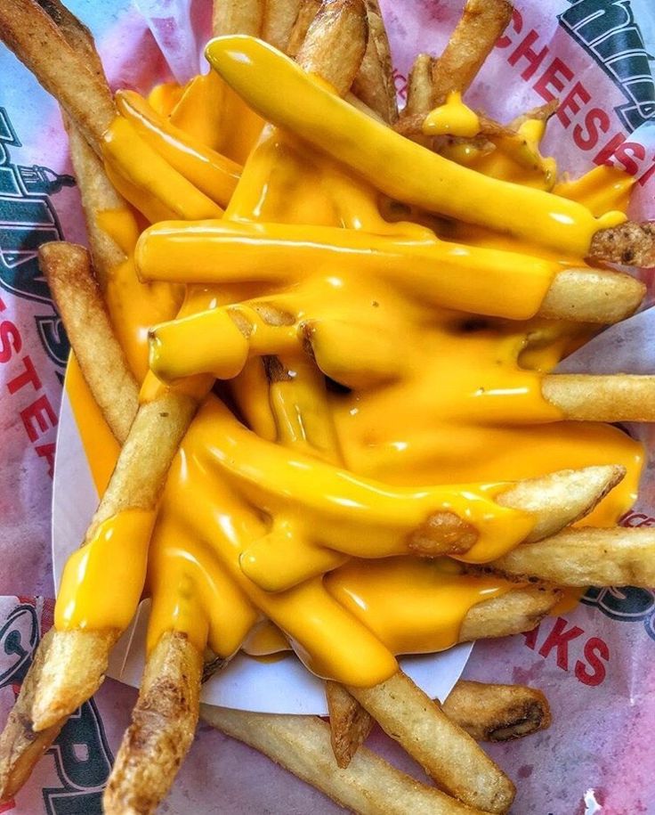 a pile of french fries covered in yellow cheese