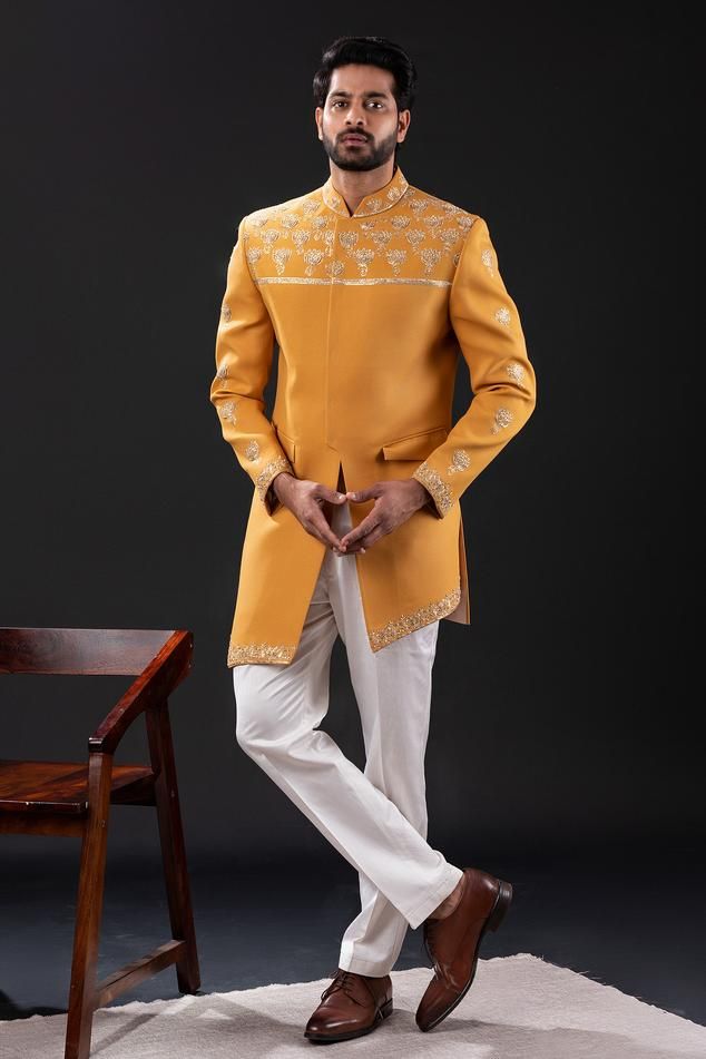 Mustard yellow long sleeves sherwani with padma pitta embroidery using gold sequin and pearl beads highlights. Paired with a white straight pant.
Components: 2
Pattern: Embroidered
Type Of Work: Padma Bloom
Neckline: Mandarin Collar
Sleeve Type: Long
Fabric: Moss Crepe, Cotton
Color: Yellow
Other Details: 
Approx weight: 3kgs
Poly lining
Occasion: Wedding - Aza Fashions Pitta Embroidery, Embroidered Sherwani, Gold Sequin, Straight Pants, Mandarin Collar, Aza Fashion, Mustard Yellow, Pearl Beads, Sleeve Type