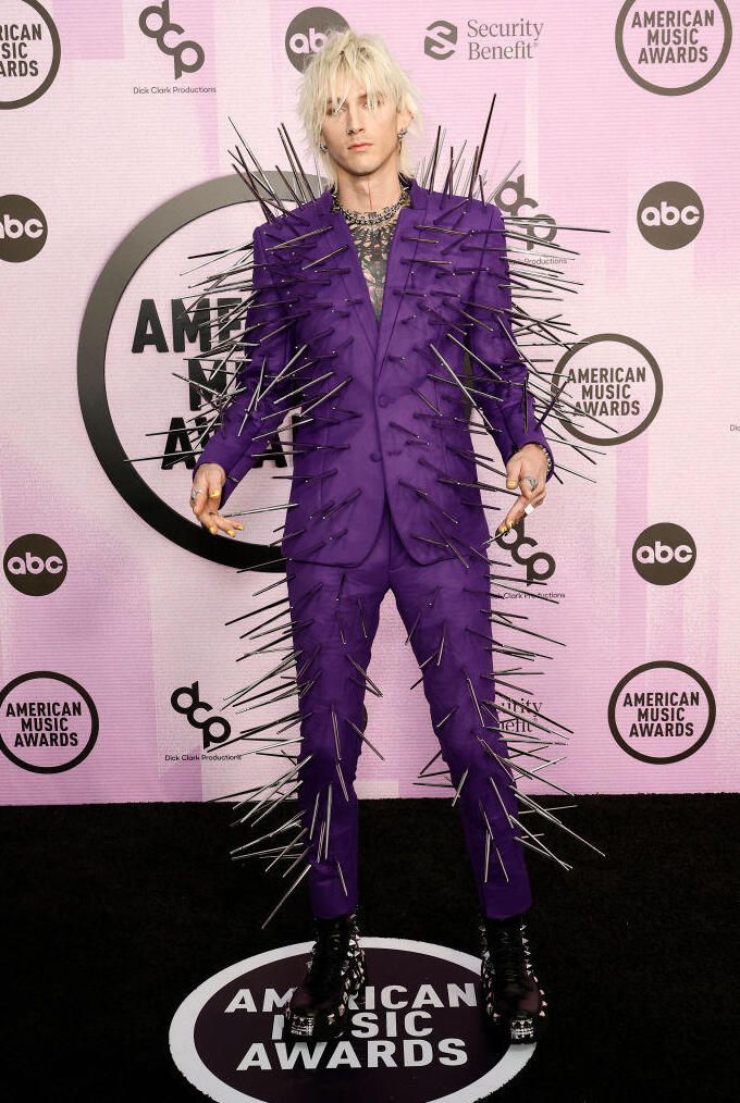 man in purple suit with spikes on his legs at an american music awards red carpet