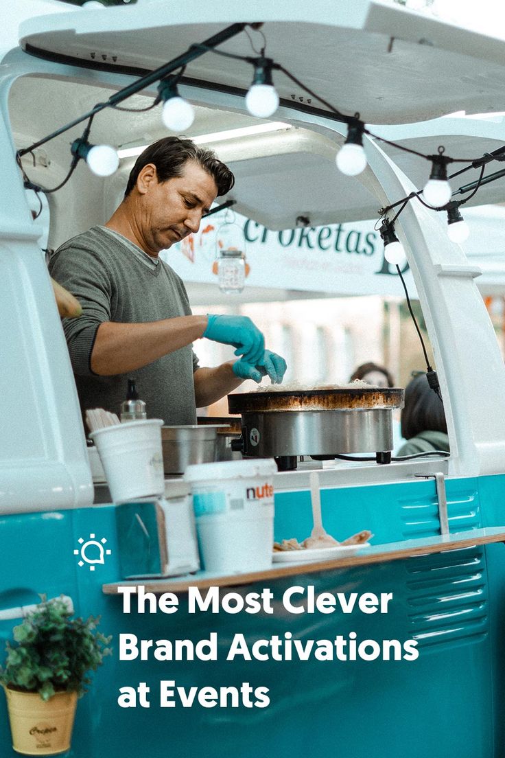 a man cooking food on top of a blue and white truck with the words the most clever brand activates at events