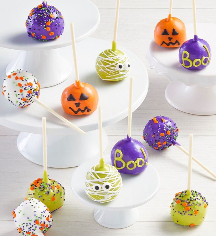 cake pops decorated with sprinkles and halloween faces are on a white plate