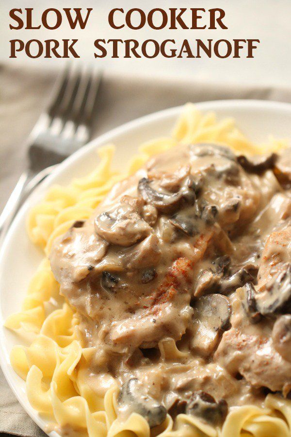 a white plate topped with pasta covered in mushroom gravy next to a fork