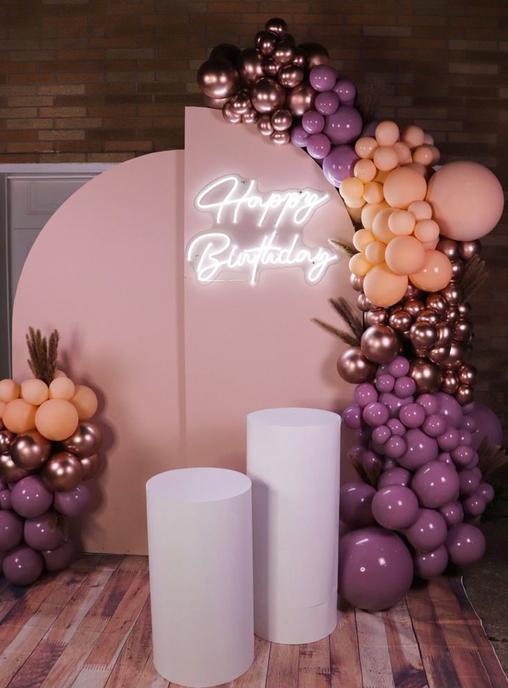 balloons and candles are arranged in front of a happy birthday sign