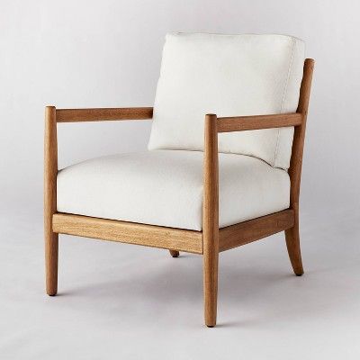 a wooden chair with white upholstered fabric on the armrests and back