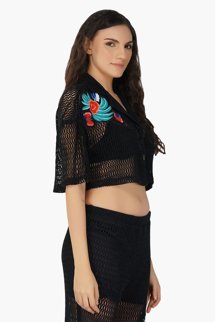 Made in cotton mesh Cropped half sleeves Black crochet mesh design Lapel collar Button-down shirt Relaxed fit Colorful hand embroidery detail in front Meet the Maison Black Embroidered Shirt, a game-changing fusion of bohemian sophistication and modern style!This cropped half-sleeve stunner is crafted from 100% cotton and showcases an intricate black crochet net design that's nothing short of mesmerizing. The vibrant blue floral embroidery, complete with whimsical butterflies, adds a pop of colo Summer Tops With Floral Embroidery And 3/4 Sleeve, Summer Floral Embroidery 3/4 Sleeve Tops, Bohemian Black Top With 3/4 Sleeves, Black 3/4 Sleeve Summer Blouse, Black Summer Blouse With 3/4 Sleeves, Black Floral Embroidered Blouse For The Beach, Black Embroidered V-neck Top For Summer, Summer Embroidered Tops With 3/4 Sleeves, Fitted Black Embroidered Top For Summer