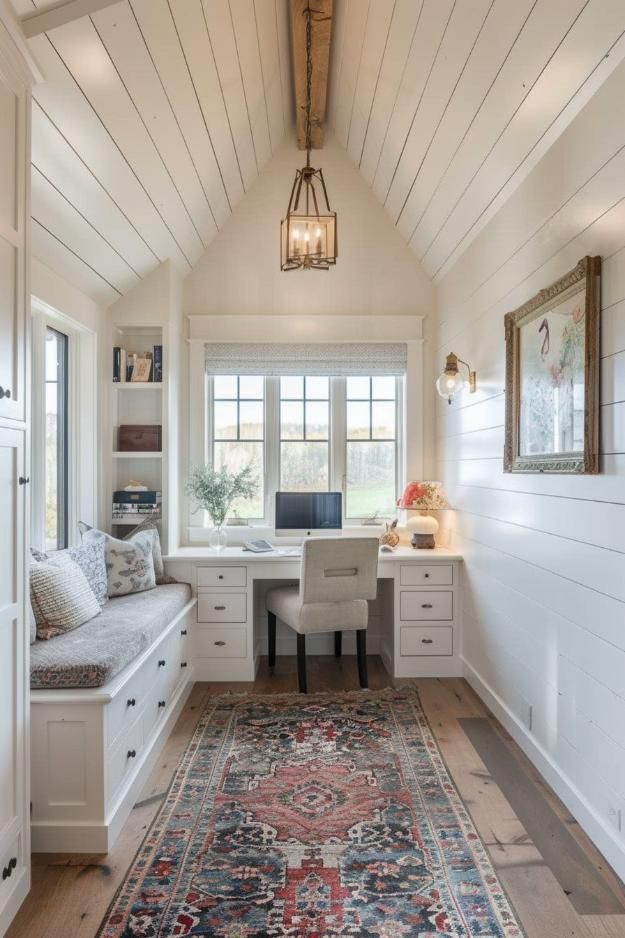 a white room with a rug, desk and window in the corner next to it