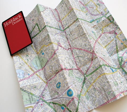 a folded map with a red book on it's top and the word holbock design