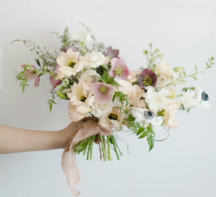 a woman holding a bouquet of white and pink flowers