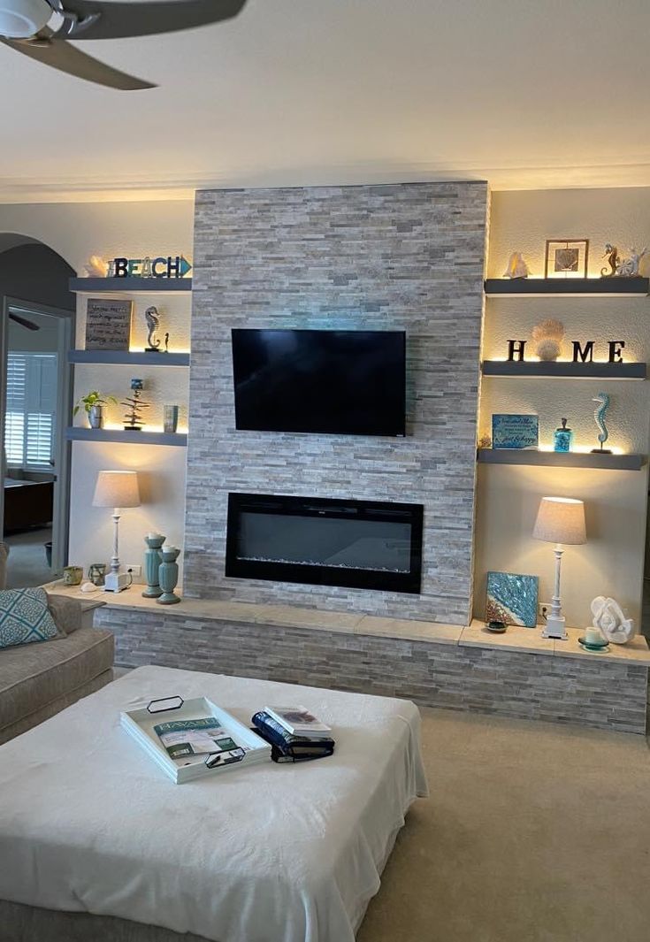 a living room with a couch, fireplace and television on the wall next to it