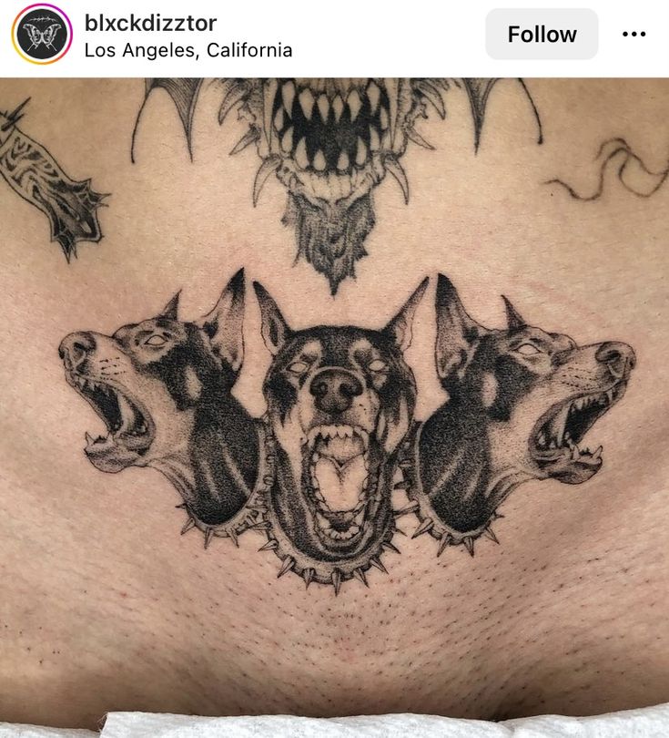 a man's chest with three dogs on it and an evil demon in the background