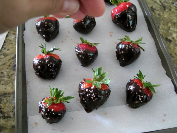 chocolate covered strawberries sitting on top of a baking sheet