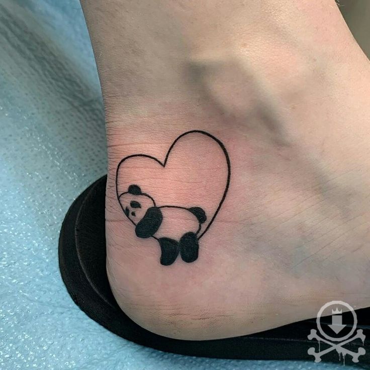 a panda bear tattoo on the foot of a person with a heart shaped panda bear