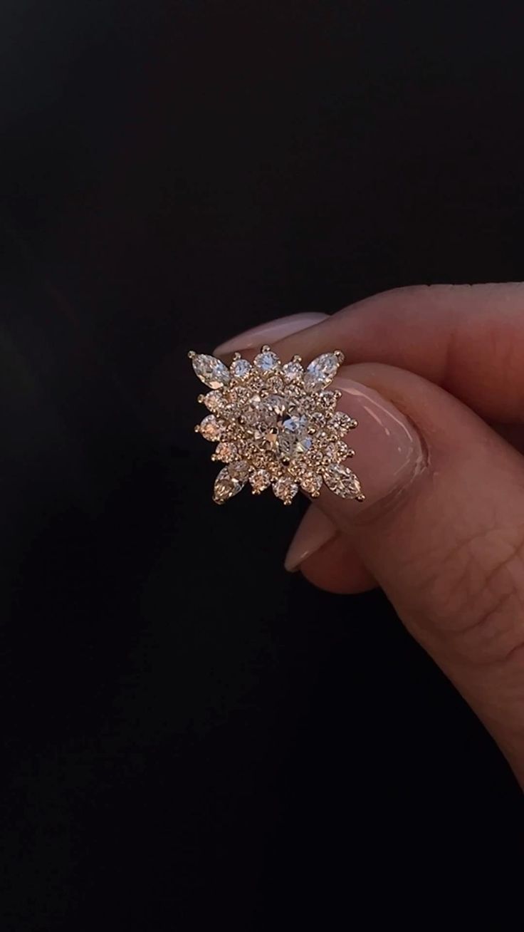 a woman's hand holding a gold and diamond ring