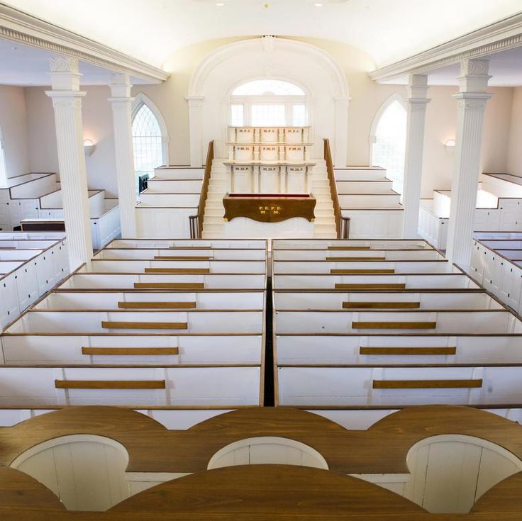 an empty church with wooden pews and white walls