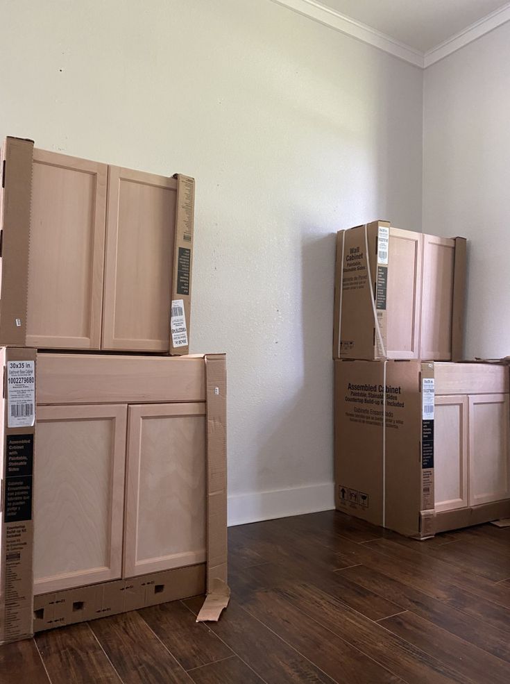 boxes are stacked on top of each other in an empty room with hard wood flooring