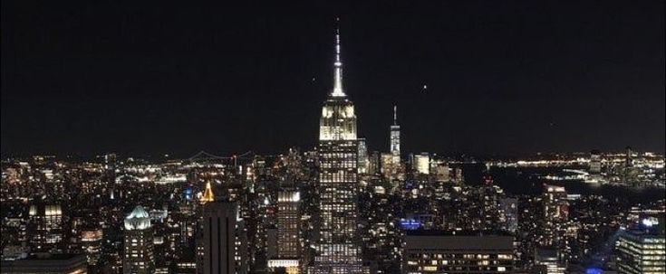 an aerial view of new york city at night with the empire building in the foreground