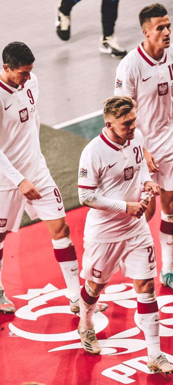 the soccer players are walking on the field together in uniform and ready to kick the ball