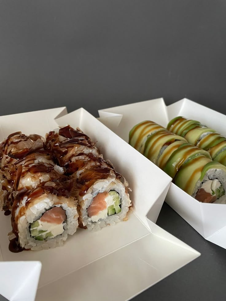 sushi and apple slices in white boxes on a table