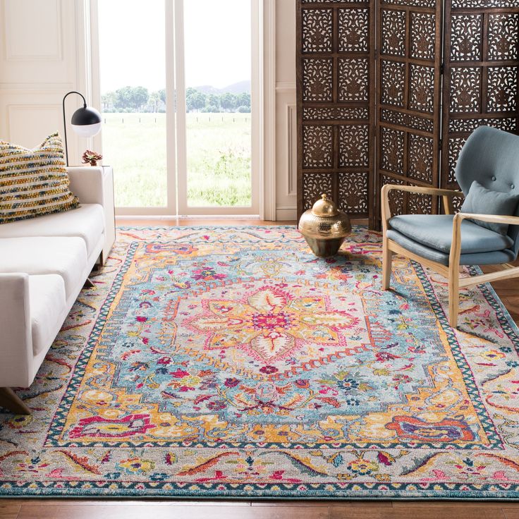 a living room filled with furniture and a large rug on top of a hard wood floor