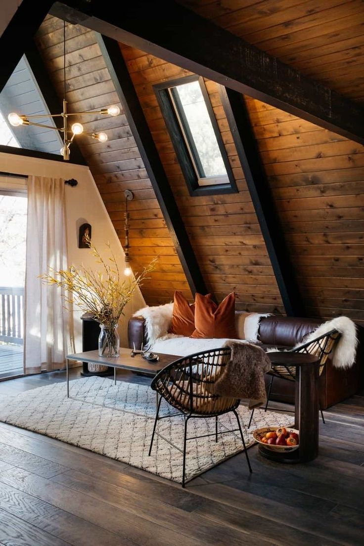 a living room filled with furniture and lots of wooden walls on top of a roof