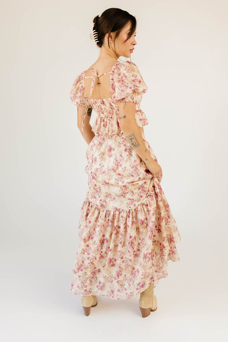 make everyone stop, stare, + have severe outfit envy with this iconic pink floral maxi skirt set. featuring a puff sleeve peplum cropped top + a matching flowy maxi skirt, it’s full of vintage vibes + versatility. you can wear the pieces together as a flirty formal ensemble, or separately to elevate any outfit. cream pink floral // square neckline, cropped, elastic cuffs, smocked back, elastic shoulders, tie back, maxi length, elastic back waist, ruffle skirt, lined skirt model is 5'8" + wearing Pink Floral Print Maxi Dress With Puff Sleeves, Garden Party Ruffled Maxi Skirt, Fitted Pink Floral Print Maxi Skirt, Fitted Pink Floral Maxi Skirt, Feminine Floral Print Maxi Dress With Puff Sleeves, Feminine Floral Print Puff Sleeve Maxi Dress, Feminine Fitted Floral Print Maxi Skirt, Feminine Pink Maxi Skirt With Ruffles, Feminine Pink Ruffled Maxi Skirt