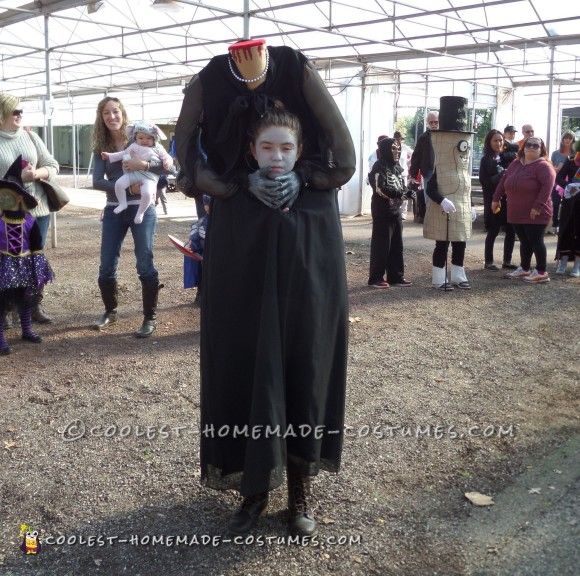 a man in a costume standing next to a little boy with his head on his shoulders