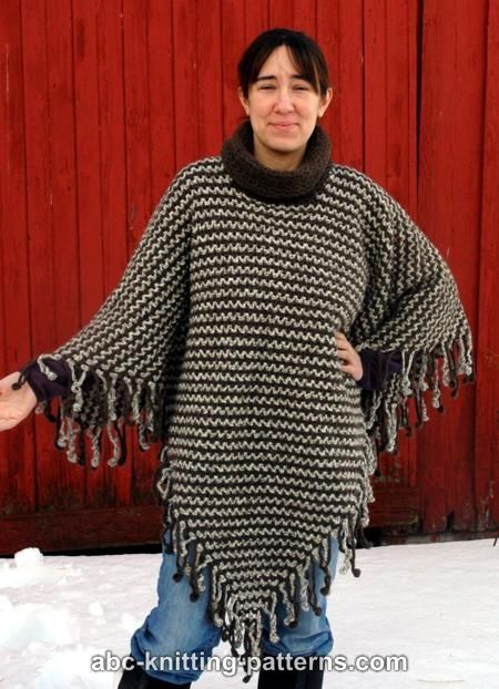 a woman standing in the snow wearing a black and white knit ponchy sweater