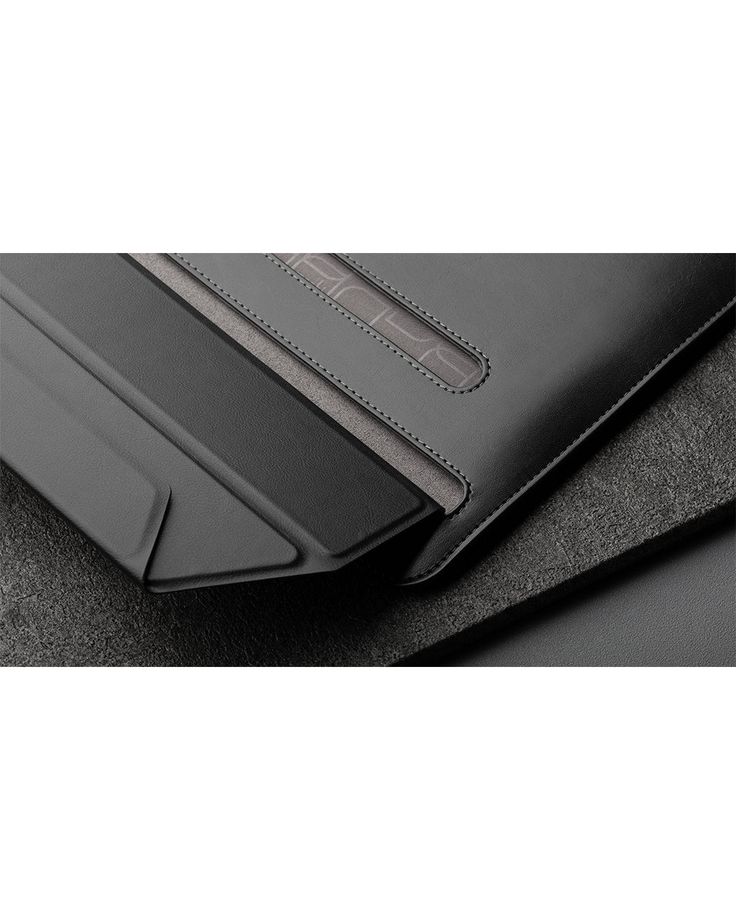 two pieces of black leather sitting next to each other on top of a gray surface