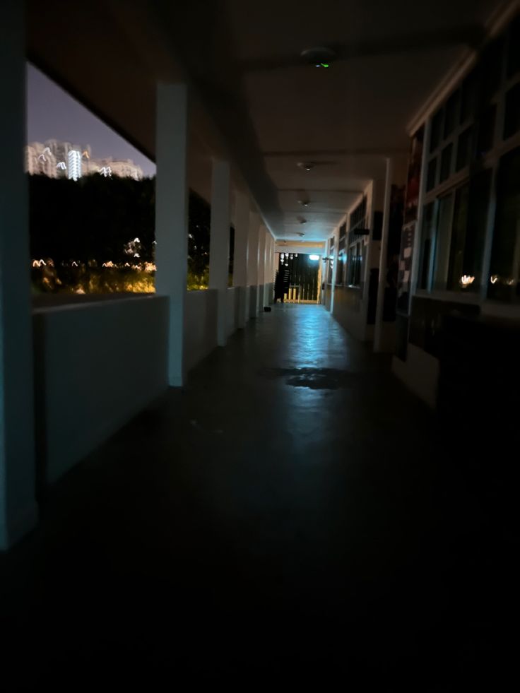 an empty hallway with no people in it at night or day time, and the city lights can be seen through the windows