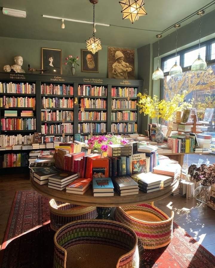 a room filled with lots of books on top of a table