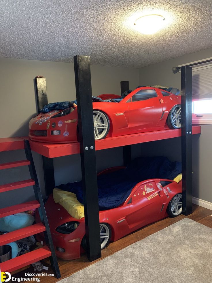 a room with two bunk beds and cars on the bottom level, one is red