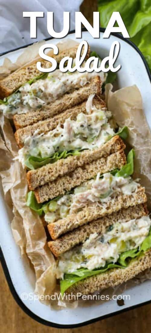 tuna salad sandwich with lettuce and mayonnaise on toasted bread in a white dish