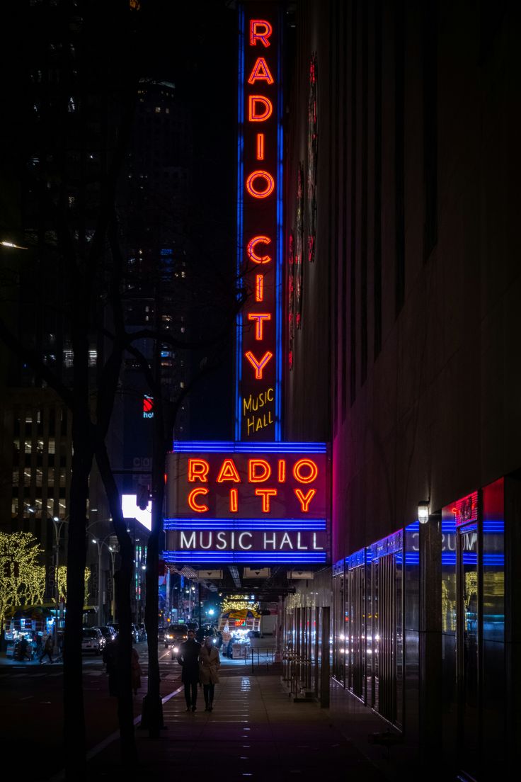 the radio city music hall sign is lit up in red, white and blue colors