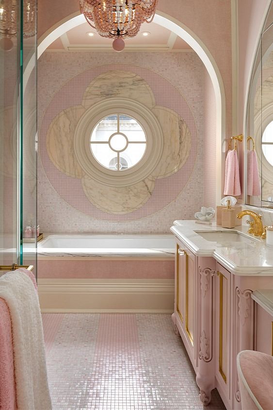 a fancy bathroom with pink walls and gold trim