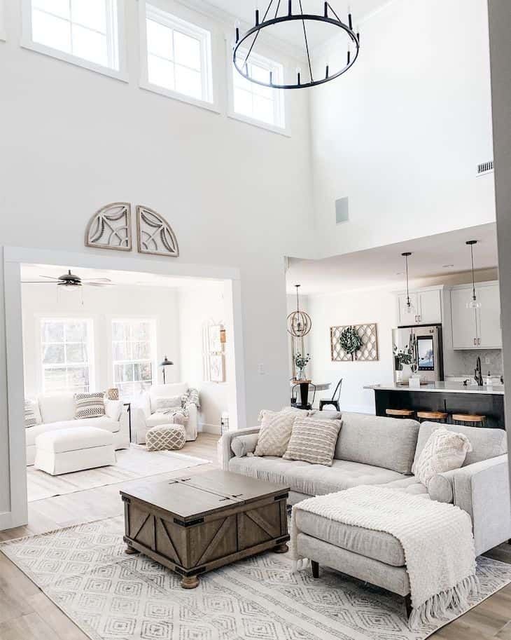 a living room filled with furniture and a chandelier hanging over the top of it