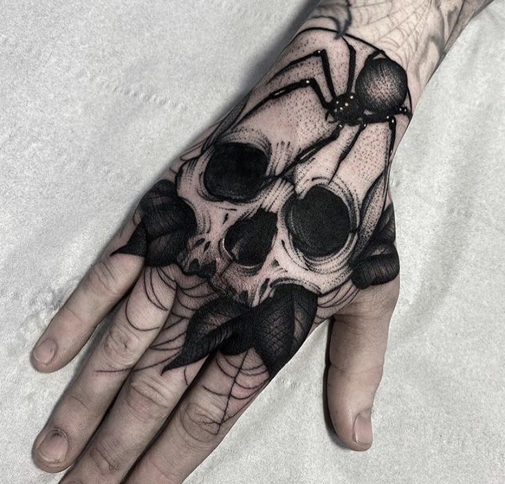 a hand with a skull and spider on it