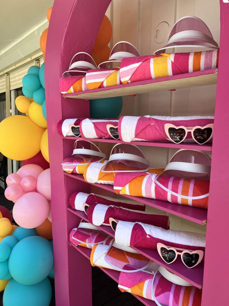 there are many colorful balloons and hats on the shelves in front of this display case