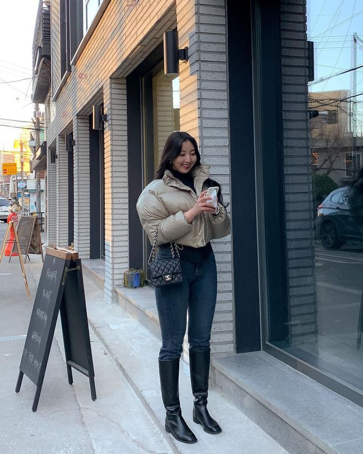 a woman standing on the sidewalk with her cell phone