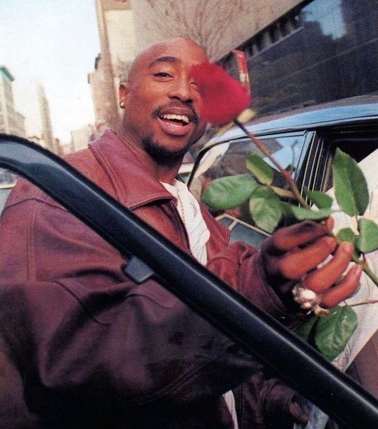 a man is holding a rose in his hand and the caption reads keep ya head up, girl