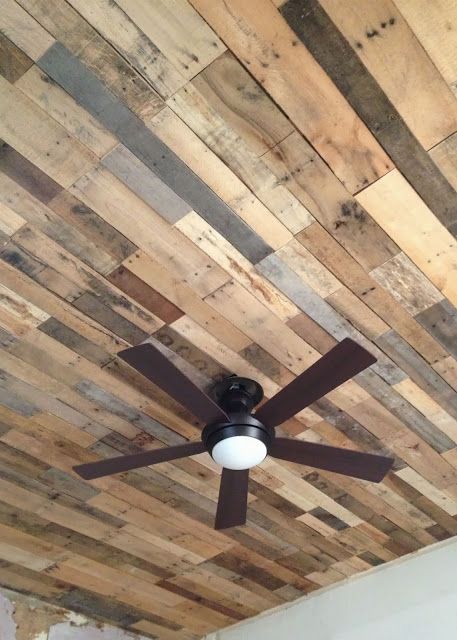 a ceiling fan that is mounted to a wood paneled ceiling with wooden planks