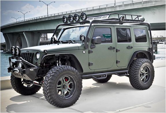 a green jeep parked in front of a bridge