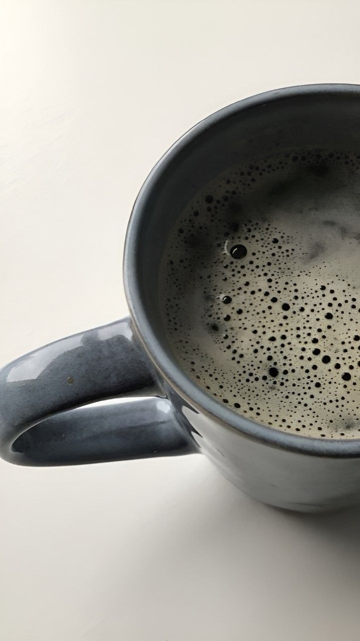 a metal cup filled with liquid on top of a table