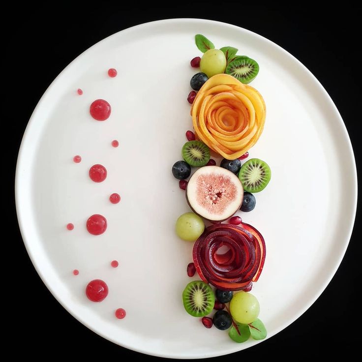 a white plate topped with sliced fruit and veggies on top of each other