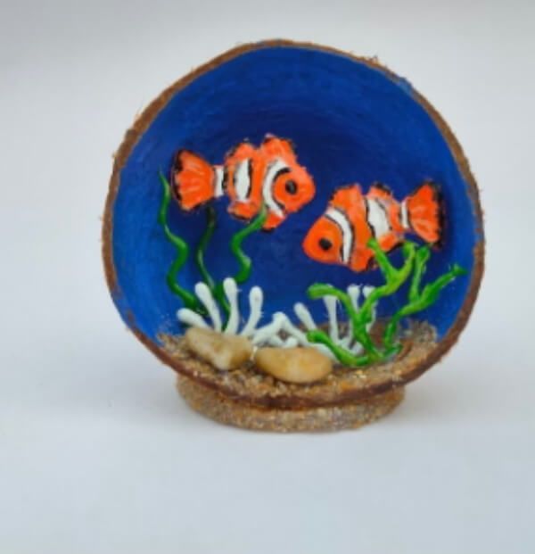 an orange and white clown fish sitting on top of a blue bowl with corals