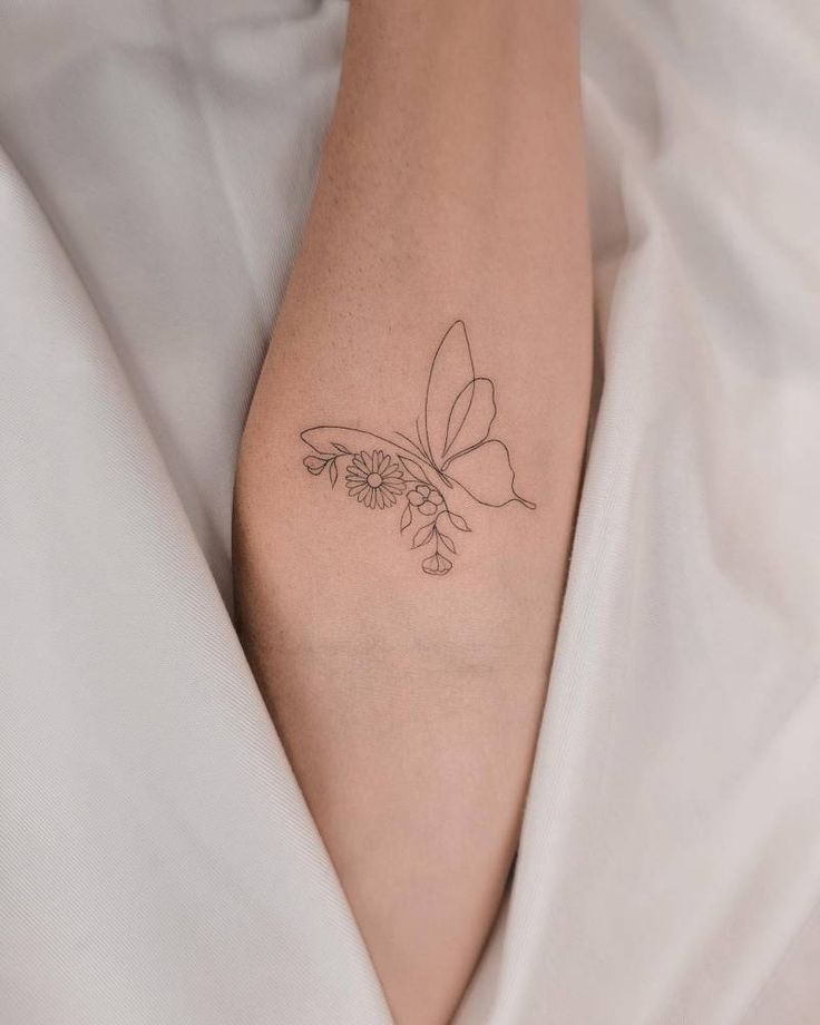 a woman's foot with a butterfly tattoo on her left leg and flower in the middle